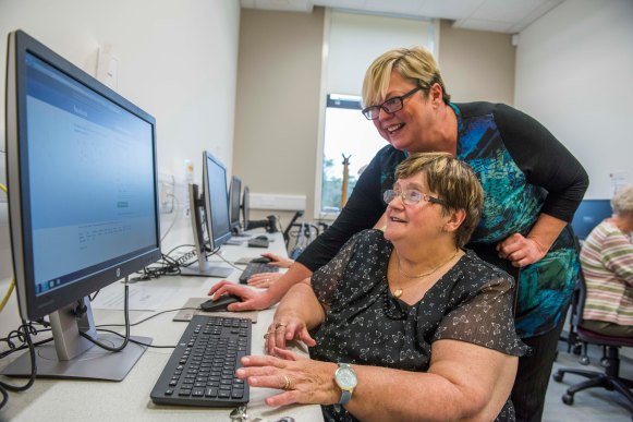 Mary being helped to use a computer