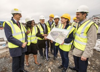Stakeholders in high visibility jackets looking at a drawing of a planned development