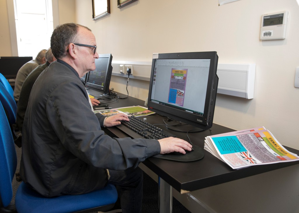 Steve sitting at a computer writing the monthly newsletter