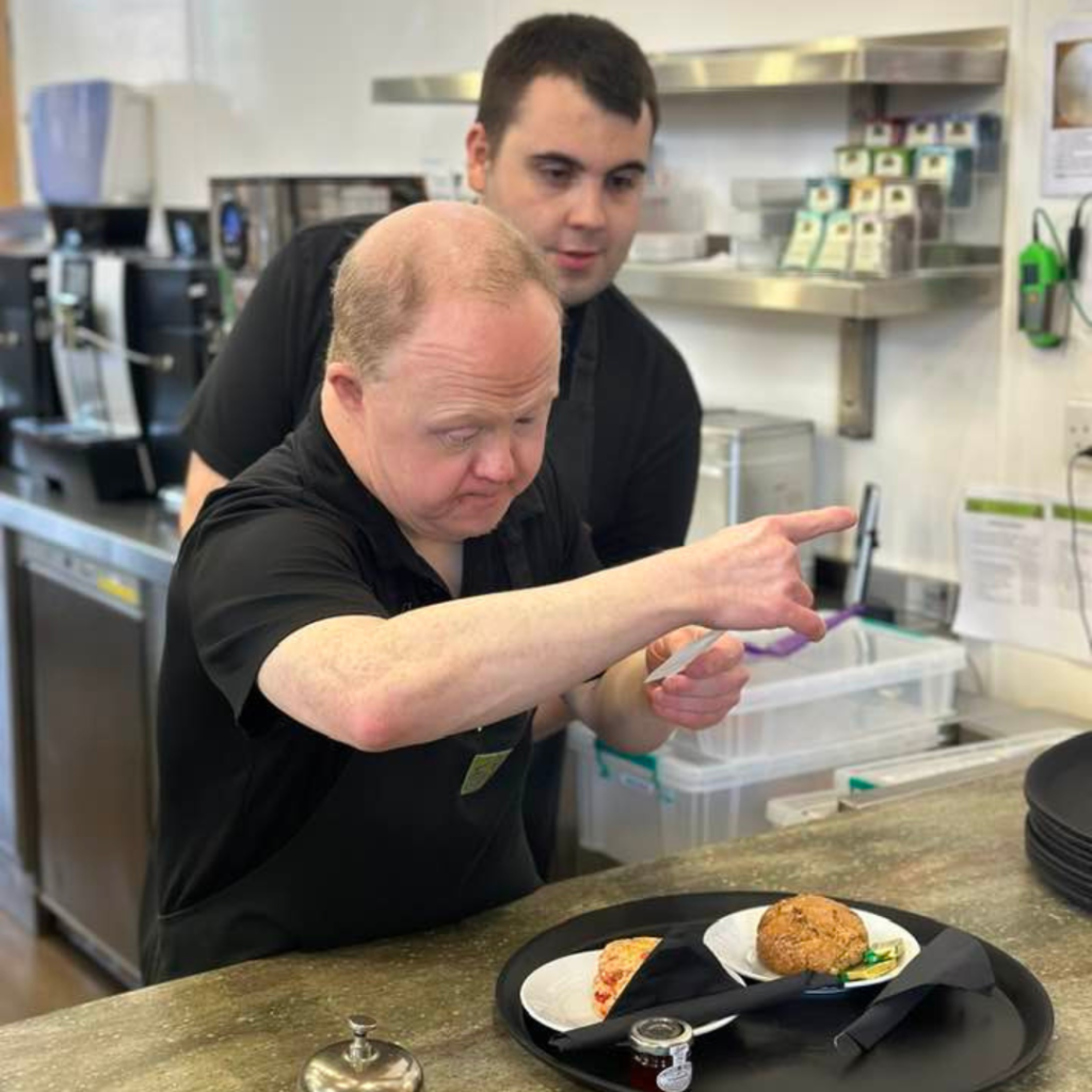 Volunteer David checks the order as he prepares to take the tray of scones over to a table in the cafe.