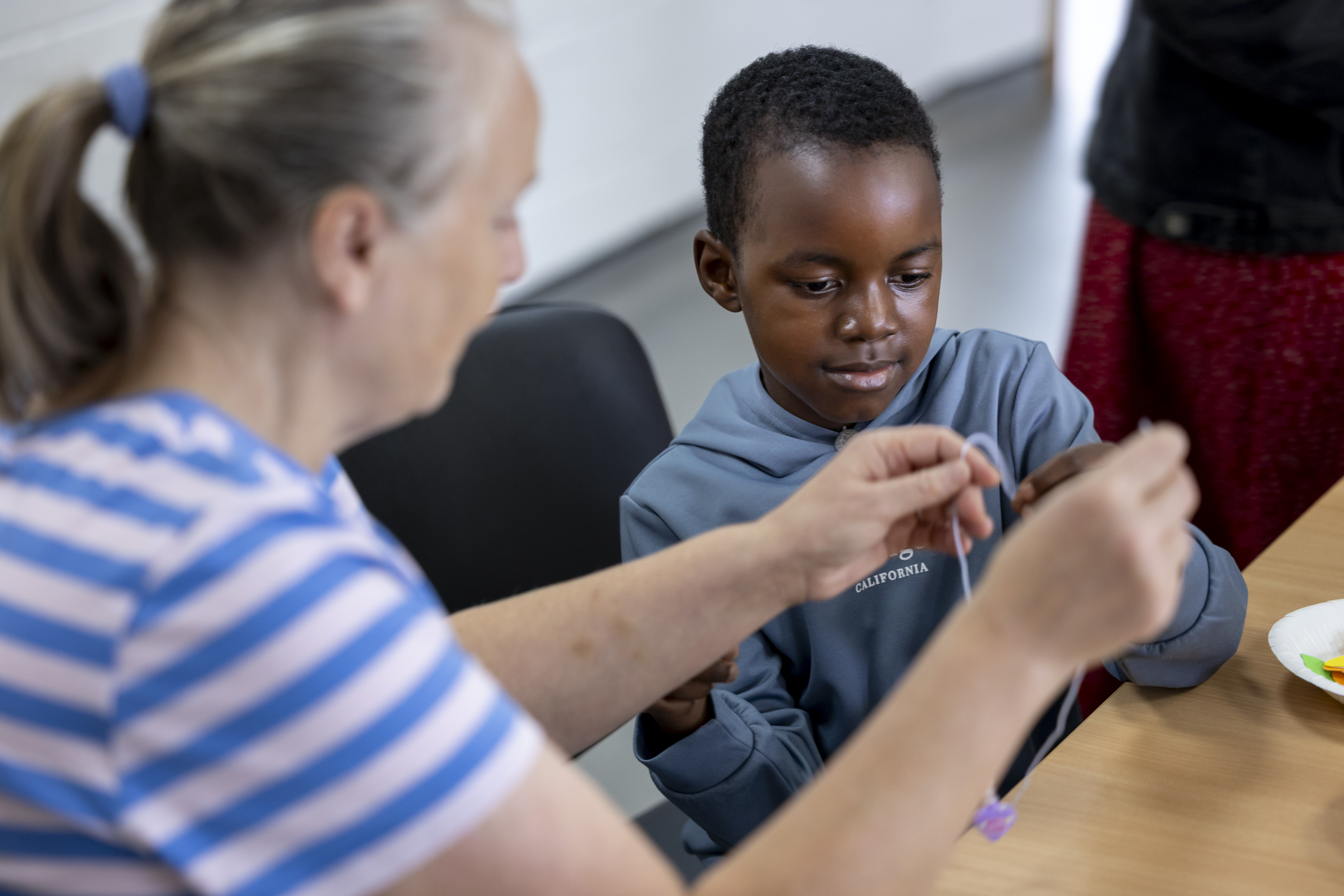 Boy sitting at desk with older lady